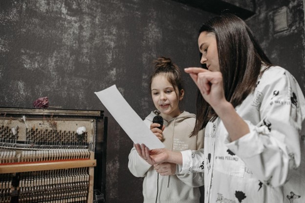 Music teacher teaching a girl how to sing